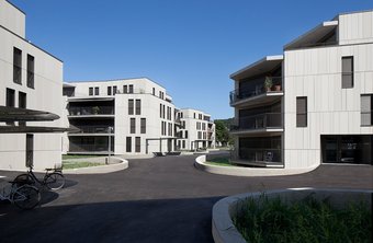 Hinterlüftete Fassade mit einer Bekleidung aus crèmeweissen, unterschiedlich
grossformatigen, vertikalen Terracottaplatten.